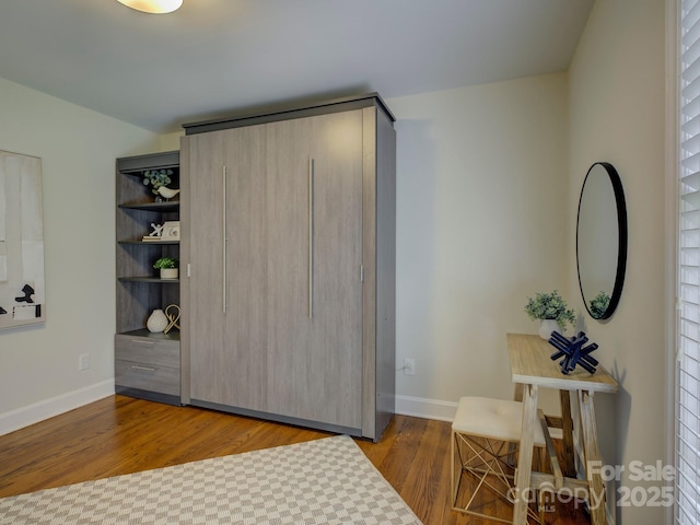 bedroom with wood finished floors and baseboards