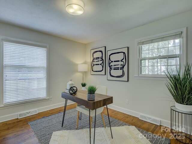 office space with baseboards, visible vents, and a healthy amount of sunlight