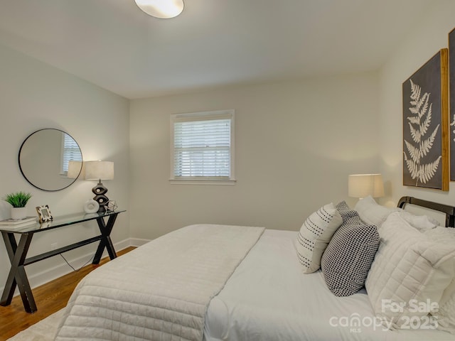 bedroom with baseboards and wood finished floors