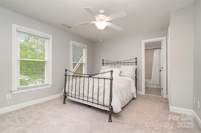 carpeted bedroom featuring visible vents, a ceiling fan, baseboards, and connected bathroom