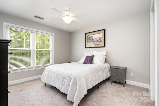 bedroom with baseboards, a ceiling fan, visible vents, and light colored carpet