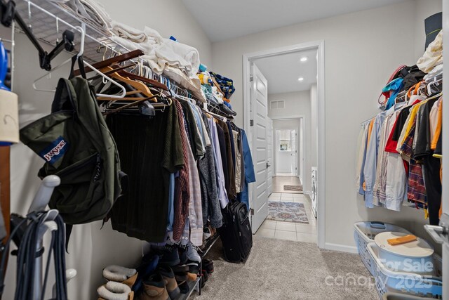 spacious closet featuring tile patterned flooring, visible vents, and carpet