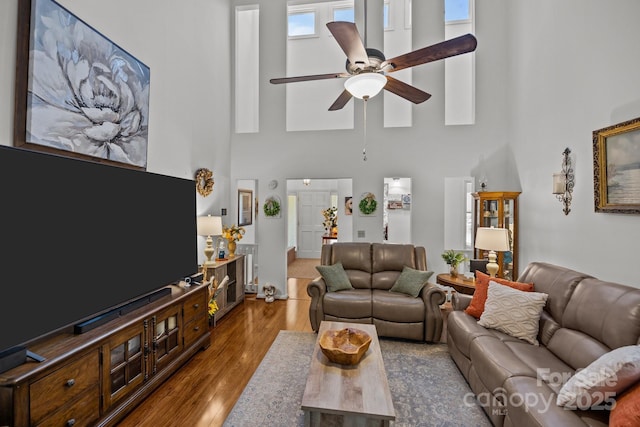 16070 Palawan Ct, Tega Cay, SC 29708 - living room featuring baseboards, wood finished floors, a towering ceiling, and ceiling fan