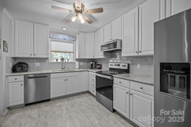 16070 Palawan Ct, Tega Cay, SC 29708 - kitchen featuring a ceiling fan, a sink, a textured ceiling, white cabinets, and appliances with stainless steel finishes