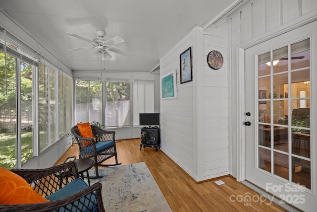 16070 Palawan Ct, Tega Cay, SC 29708 - sunroom featuring ceiling fan, a wealth of natural light, and a wood stove