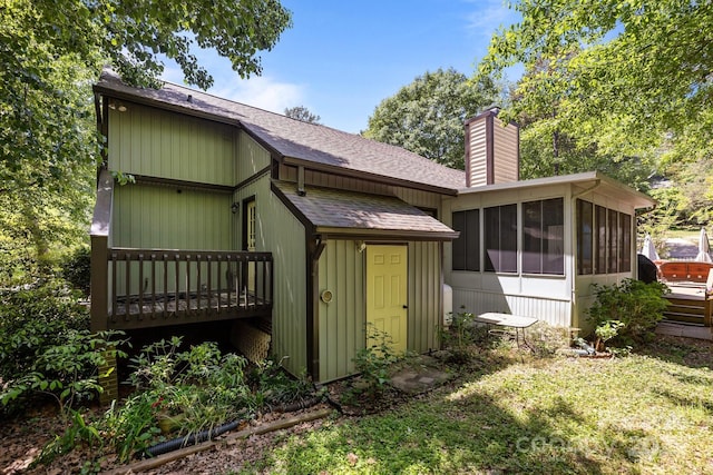 16070 Palawan Ct, Tega Cay, SC 29708 - back of property featuring a sunroom, a chimney, roof with shingles, and a deck