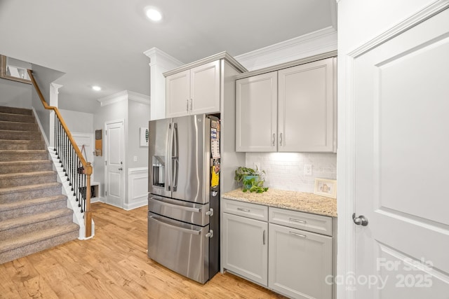 kitchen featuring crown molding, stainless steel refrigerator with ice dispenser, recessed lighting, tasteful backsplash, and light wood-style flooring