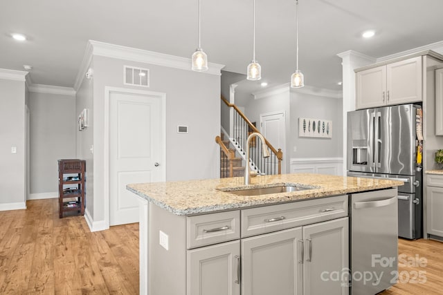 kitchen with a sink, crown molding, stainless steel appliances, and visible vents
