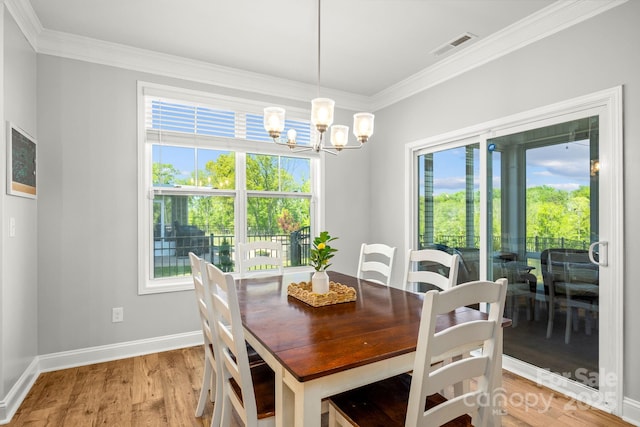 dining room with crown molding, an inviting chandelier, light wood-style flooring, baseboards, and visible vents