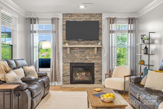 living area with ornamental molding, a fireplace, wood finished floors, and visible vents
