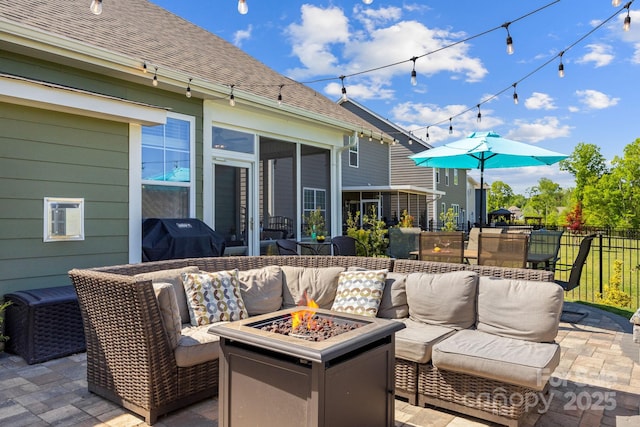 view of patio / terrace featuring area for grilling, fence, a sunroom, and an outdoor living space with a fire pit