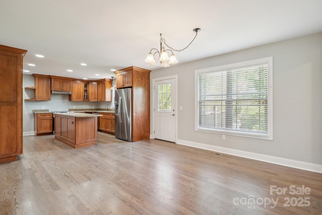 1592 Farmington Hills Dr, Conover, NC 28613 - kitchen featuring stainless steel fridge, brown cabinetry, baseboards, and under cabinet range hood