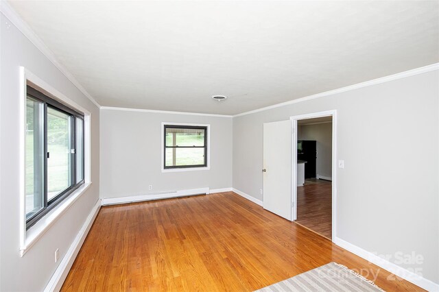 134 Piedmont Dr, Kannapolis, NC 28081 - unfurnished room featuring baseboard heating, a healthy amount of sunlight, and light wood-style floors