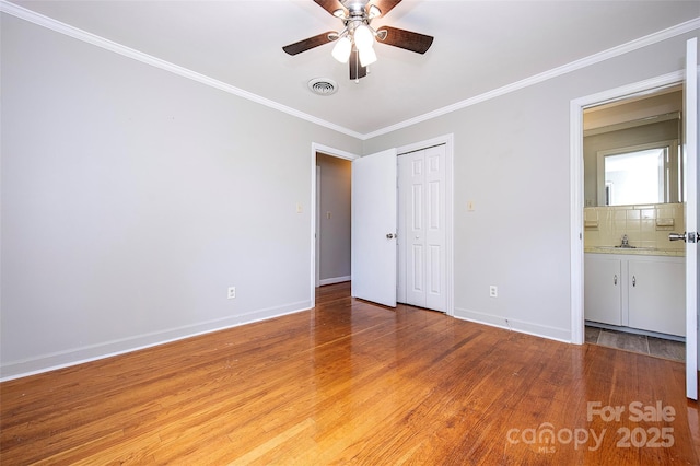 134 Piedmont Dr, Kannapolis, NC 28081 - unfurnished bedroom featuring baseboards, ornamental molding, visible vents, and light wood-style flooring