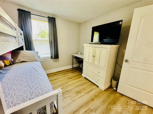 bedroom featuring light wood-style floors and baseboards
