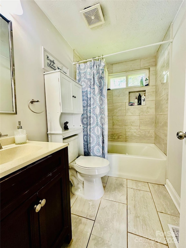 bathroom with toilet, vanity, shower / tub combo with curtain, and a textured ceiling