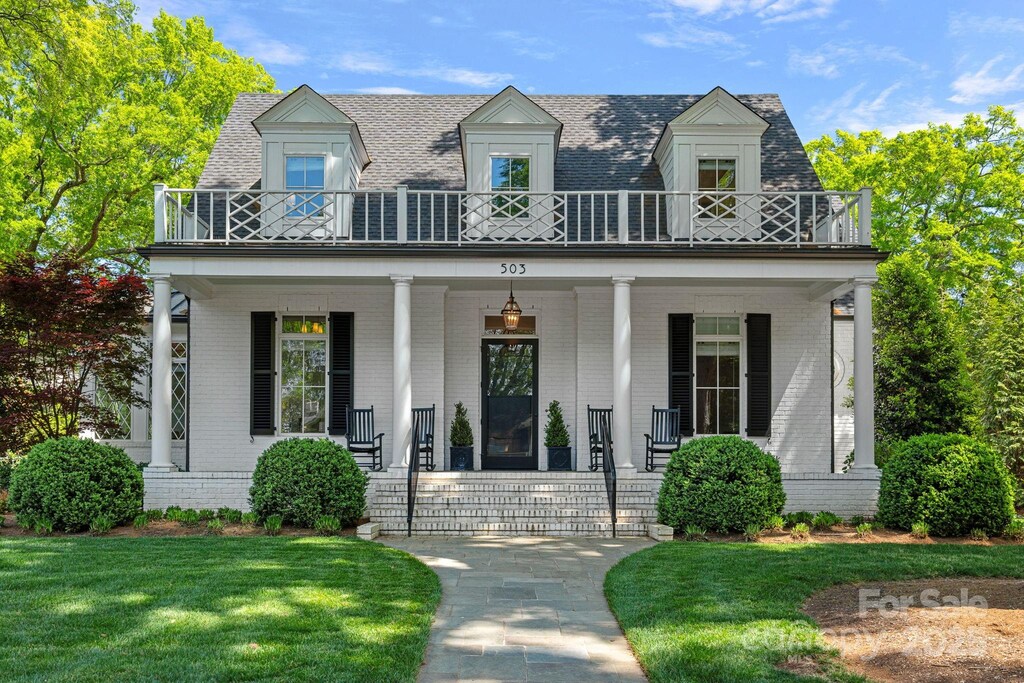 503 Walnut St, Davidson, NC 28036 - new england style home with brick siding, a balcony, a shingled roof, and a front lawn