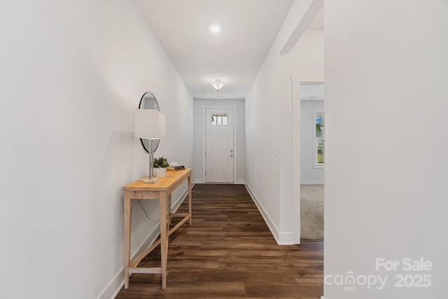 entryway featuring baseboards and dark wood-type flooring