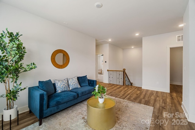 living area with recessed lighting, visible vents, wood finished floors, and baseboards