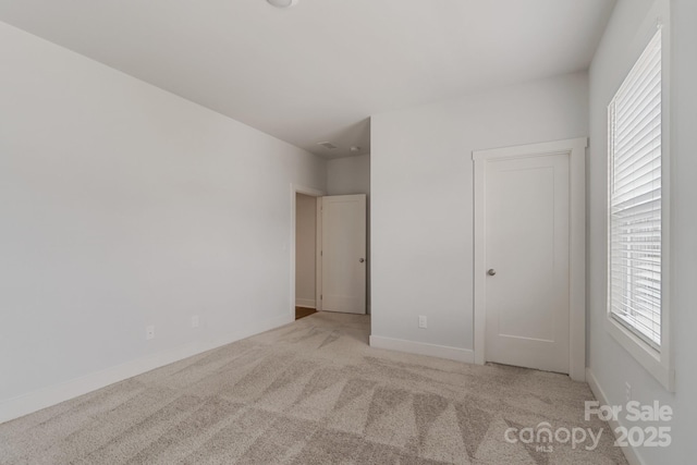unfurnished bedroom featuring baseboards and carpet