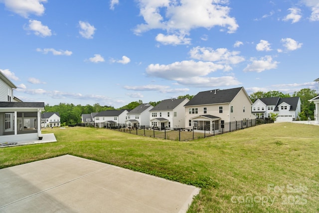view of yard with fence, a residential view, and a patio