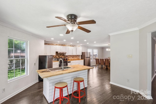 5611 Hammermill Dr, Harrisburg, NC 28075 - kitchen with stainless steel appliances, butcher block countertops, ornamental molding, decorative backsplash, and white cabinetry