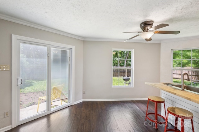 5611 Hammermill Dr, Harrisburg, NC 28075 - unfurnished dining area with dark wood-style floors, healthy amount of natural light, ceiling fan, baseboards, and ornamental molding