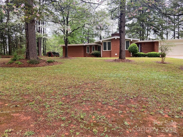 view of green lawn with driveway