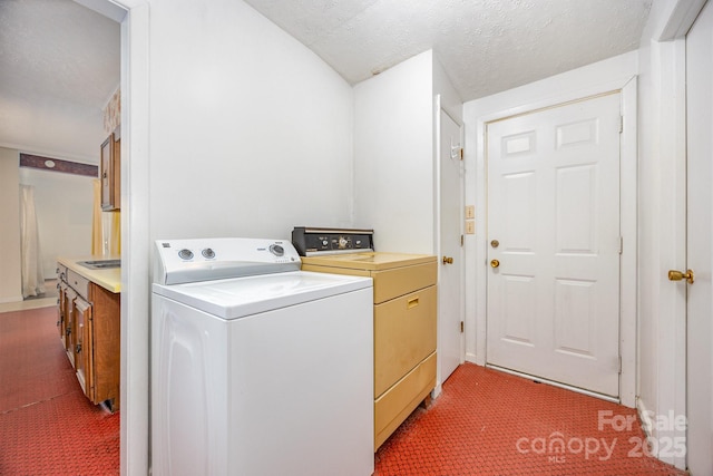 laundry area featuring light colored carpet, washing machine and dryer, and a textured ceiling