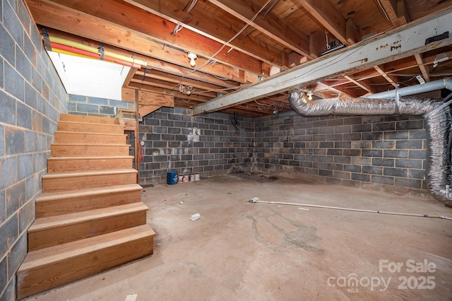 unfinished below grade area featuring stairs and concrete block wall
