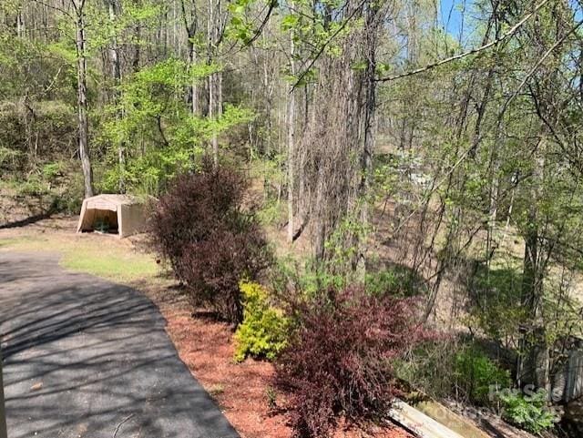 view of community featuring a wooded view and an outbuilding