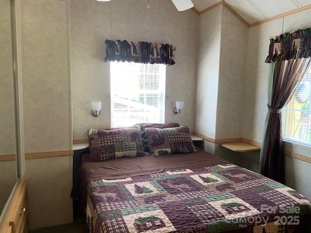 bedroom with ceiling fan, ornamental molding, and lofted ceiling