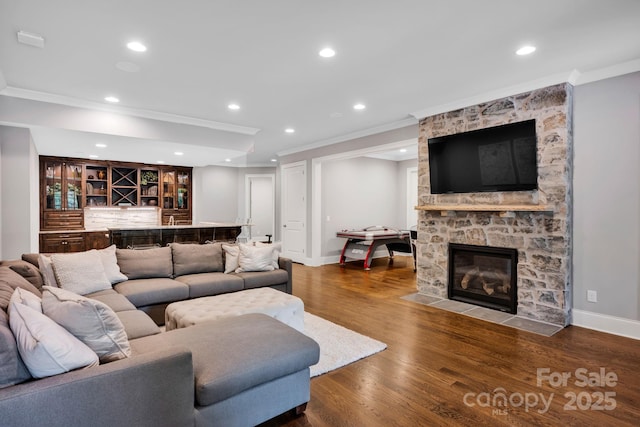 17909 Golden Meadow Ct, Davidson, NC 28036 - living room with crown molding, wet bar, a stone fireplace, baseboards, and wood finished floors