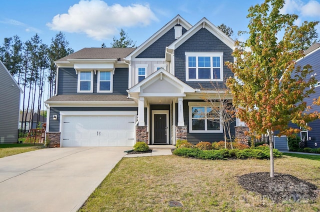 craftsman-style house with a front yard, an attached garage, stone siding, and driveway