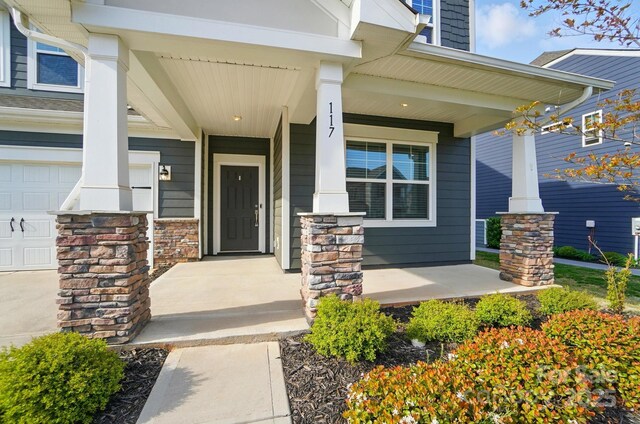 entrance to property featuring a porch and stone siding