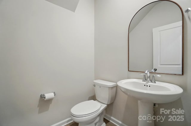 bathroom featuring baseboards and toilet