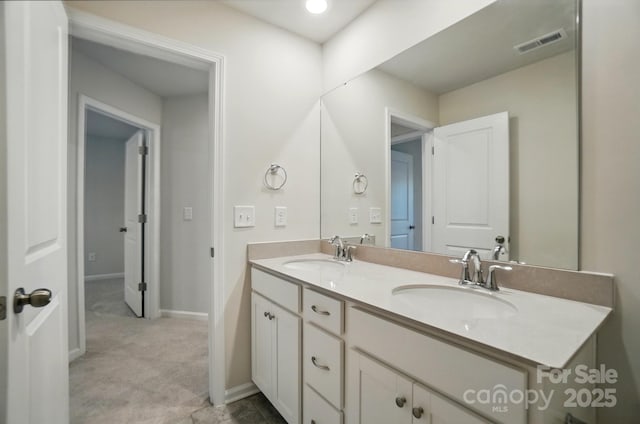 bathroom with a sink, visible vents, baseboards, and double vanity