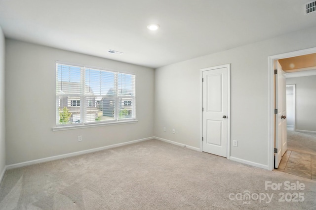 unfurnished room featuring visible vents, baseboards, and carpet flooring