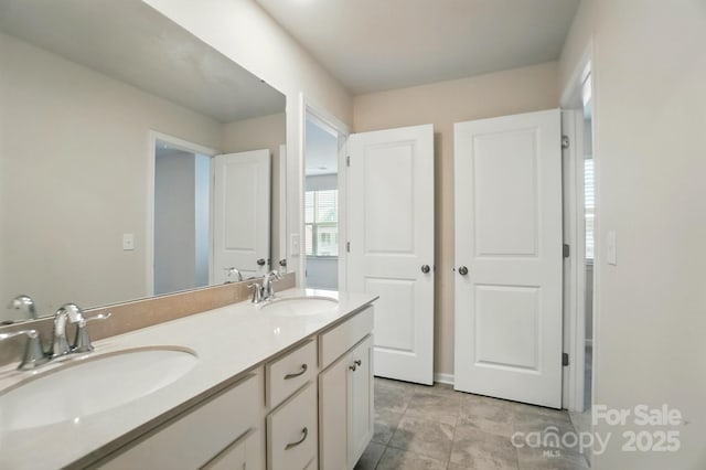 bathroom with double vanity, tile patterned floors, and a sink