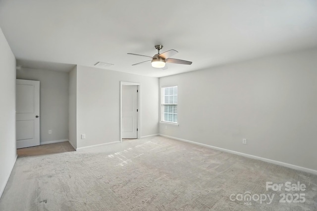 unfurnished room featuring carpet flooring, visible vents, baseboards, and a ceiling fan