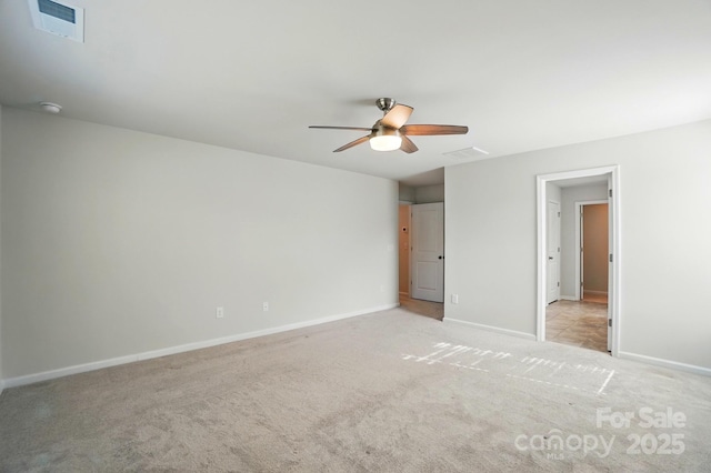 unfurnished bedroom with visible vents, light colored carpet, baseboards, and a ceiling fan