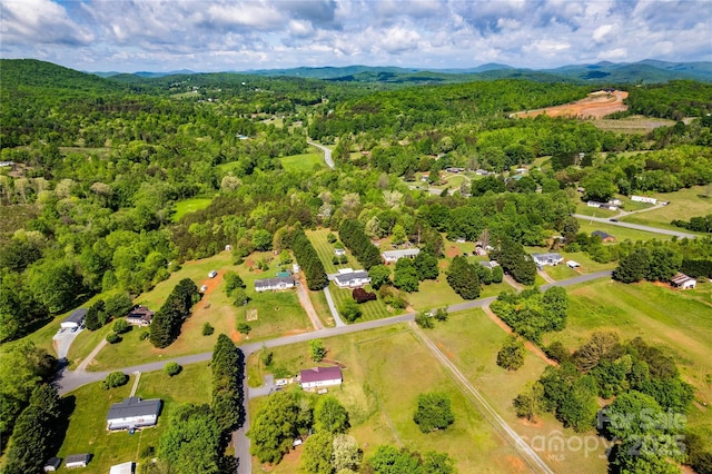 drone / aerial view featuring a mountain view and a wooded view