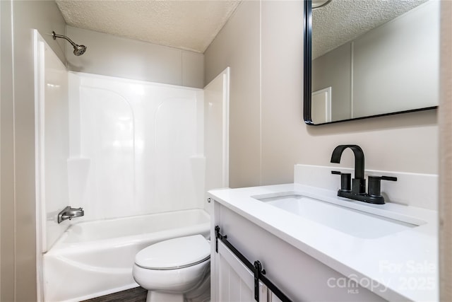 bathroom featuring toilet, a textured ceiling, tub / shower combination, and vanity