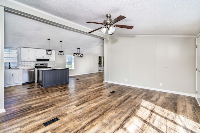 unfurnished living room with a textured ceiling, a sink, ceiling fan, visible vents, and dark wood-style flooring