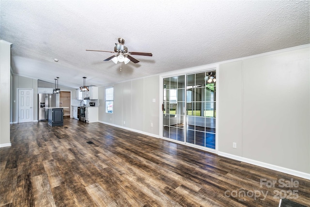 unfurnished living room featuring baseboards, a ceiling fan, a textured ceiling, and dark wood-style flooring