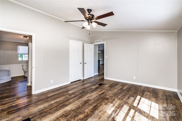 unfurnished bedroom featuring wood finished floors, a decorative wall, ornamental molding, visible vents, and a textured ceiling
