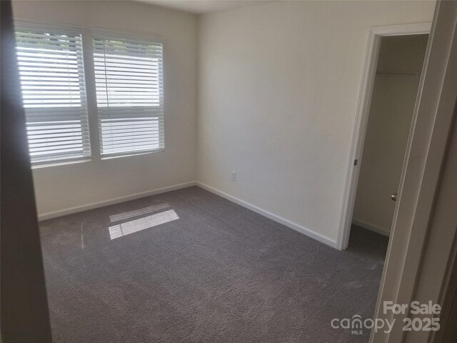 405 N Mulberry St, Cherryville, NC 28021 - unfurnished bedroom featuring a walk in closet, a closet, baseboards, and carpet