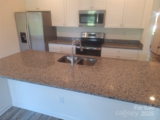 405 N Mulberry St, Cherryville, NC 28021 - kitchen with dark stone countertops, white cabinetry, a sink, and appliances with stainless steel finishes