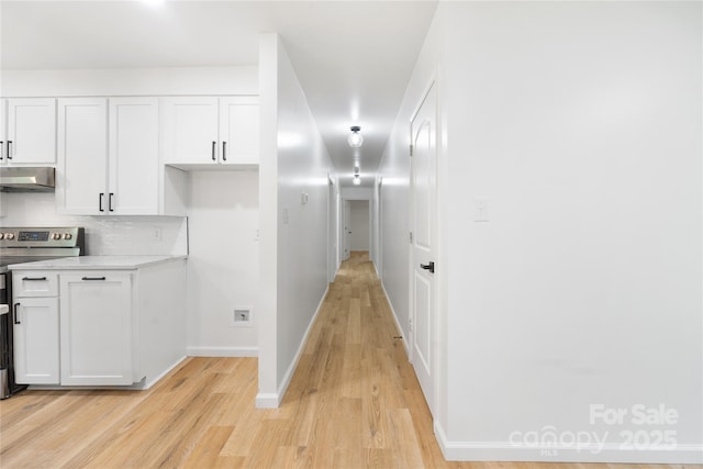 1904 27th Avenue Dr NE, Hickory, NC 28601 - kitchen featuring electric range, under cabinet range hood, light wood finished floors, white cabinets, and baseboards