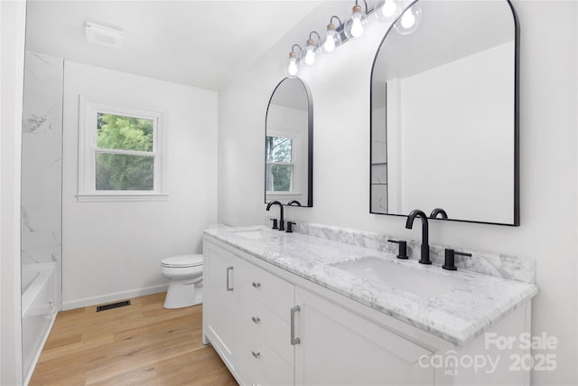 1904 27th Avenue Dr NE, Hickory, NC 28601 - bathroom featuring toilet, wood finished floors, double vanity, and baseboards